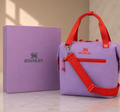 Stanley soft cooler lunch bag in lavender purple with red handles and crossbody strap, shown with gift box