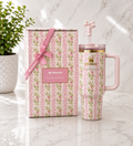 Stanley x LoveShackFancy Quencher tumbler in pink floral print with blush pink handle and bow straw topper, shown with matching floral gift box tied with pink ribbon