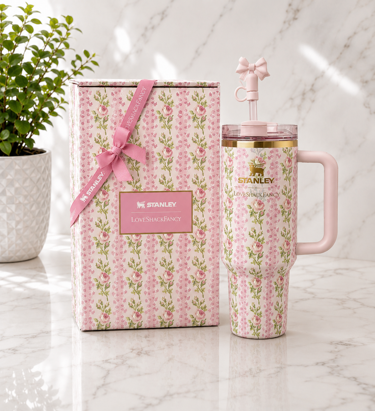 Stanley x LoveShackFancy Quencher tumbler in pink floral print with blush pink handle and bow straw topper, shown with matching floral gift box tied with pink ribbon