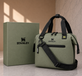 Stanley soft cooler lunch bag in olive green with black handles and crossbody strap, shown with olive green Stanley gift box