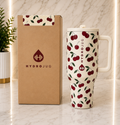HydroJug Cherry Print 40oz Tumbler with cream handle and lid next to HydroJug gift box on marble surface