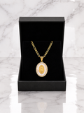 Virgin Mary Medallion Necklace with 18K gold Figaro chain and CZ halo in luxury black gift box on marble surface