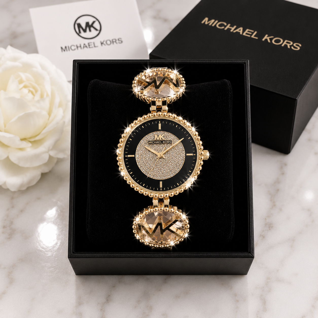 Michael Kors Ladies Quartz Watch with black and gold pave crystal dial and MK champagne crystal bracelet in luxury gift box on marble surface