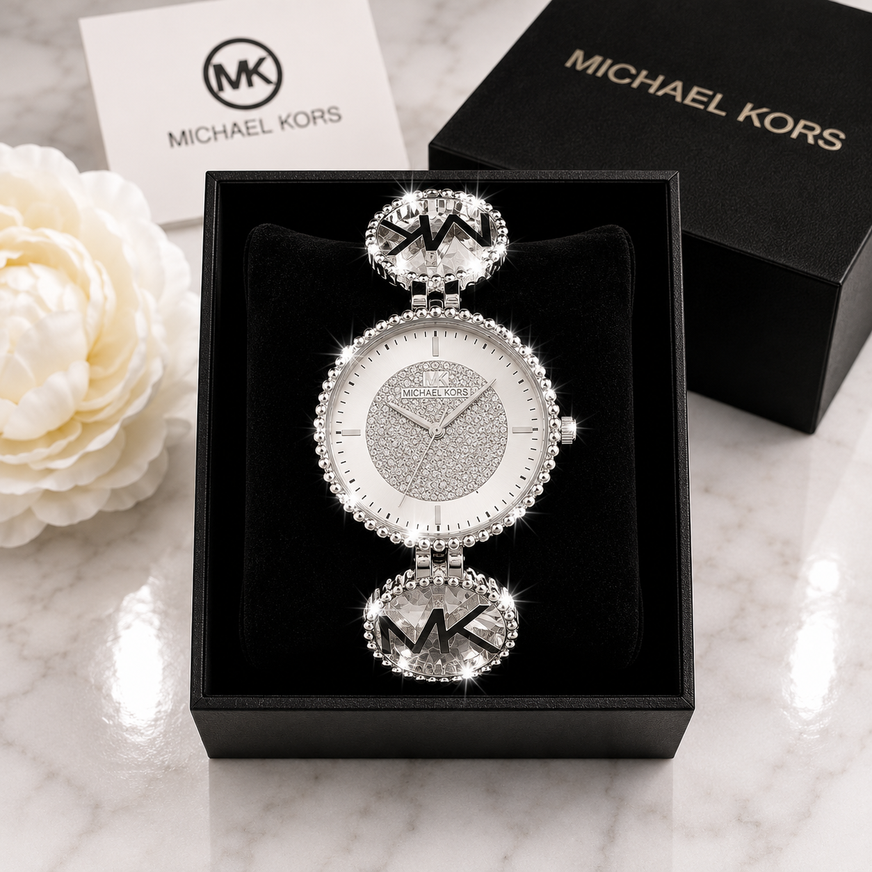 Michael Kors Ladies Quartz Watch with silver pave crystal dial and MK crystal oval link bracelet in luxury gift box on marble surface
