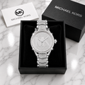 Michael Kors Ladies Quartz Watch all silver iced out with pave MK logo dial and full crystal chevron bracelet in luxury gift box on marble surface