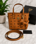 MCM Visetos Mini Tote Bag in cognac brown with bear charm and crossbody strap