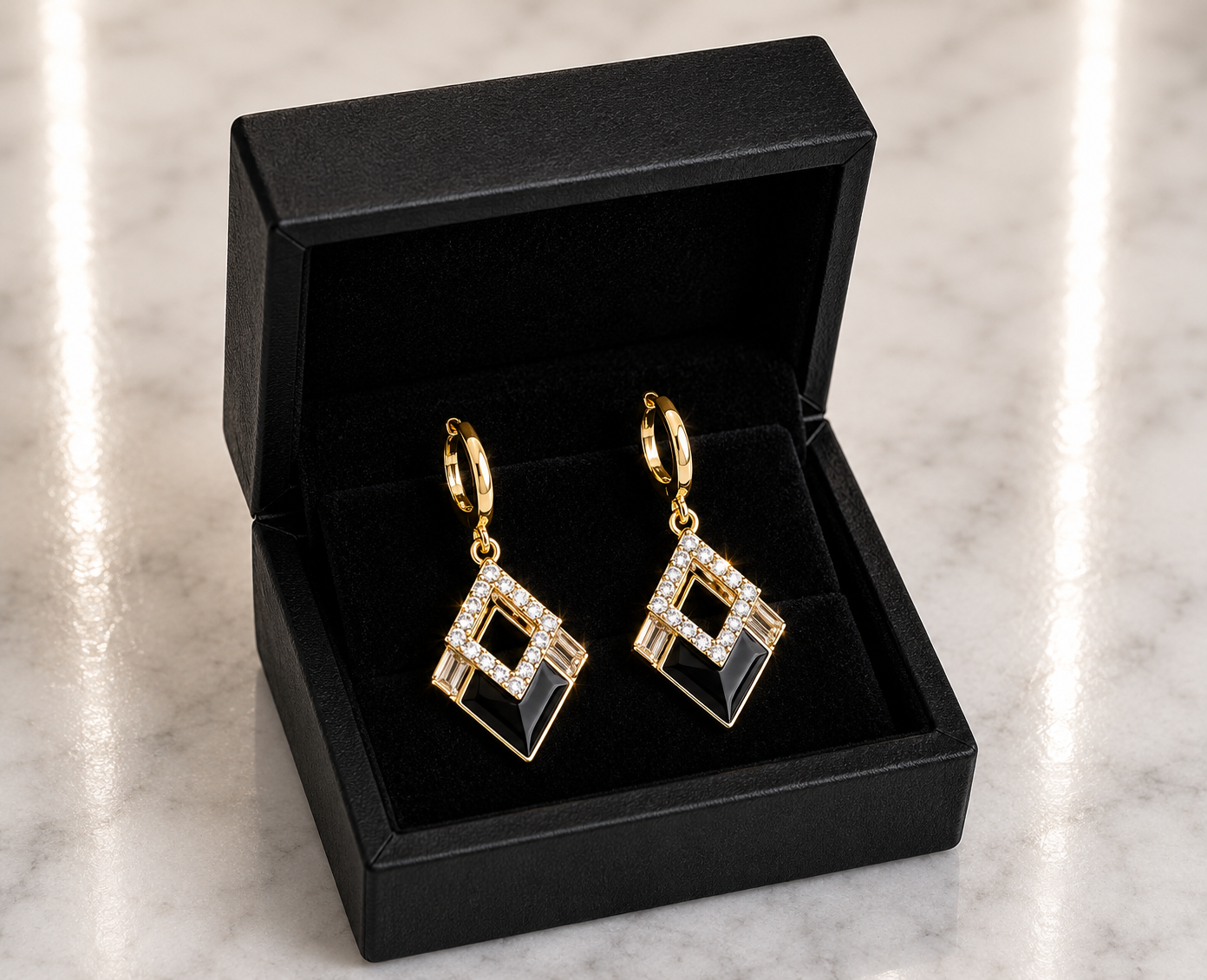 Black Onyx and CZ Diamond Huggie Drop Earrings in 18K gold tone displayed in a black luxury gift box