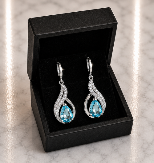 Aqua Blue Topaz Teardrop and CZ Swirl Huggie Drop Earrings in silver displayed in a black luxury gift box