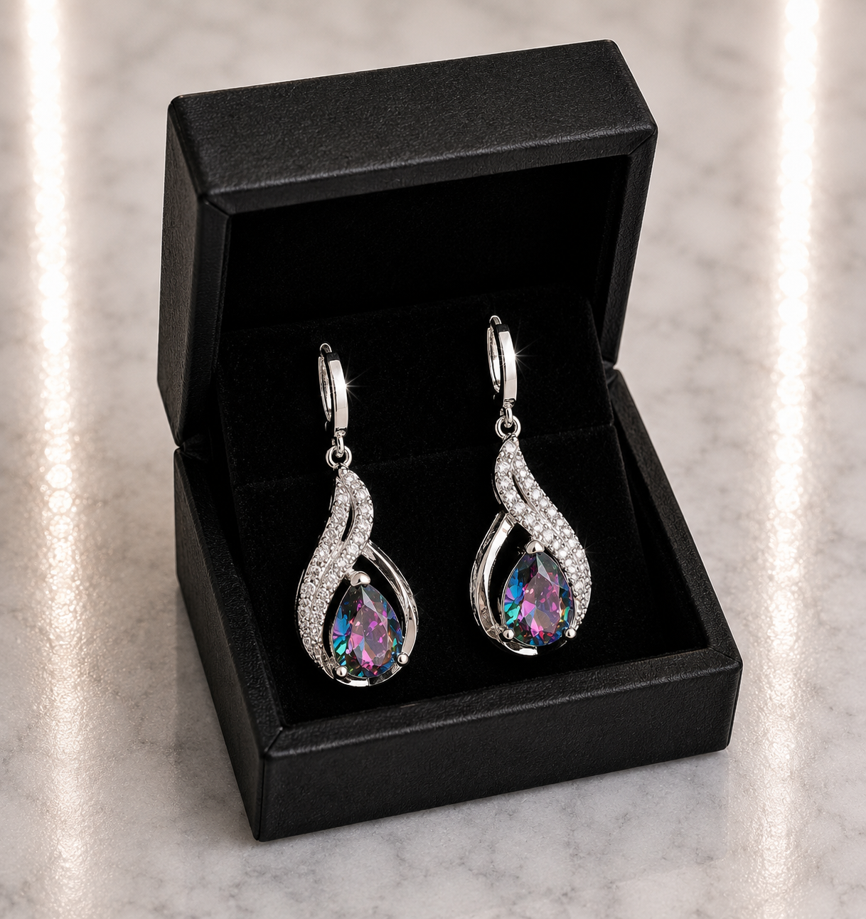 Mystic Rainbow Topaz Teardrop and CZ Swirl Huggie Drop Earrings in silver displayed in a black luxury gift box